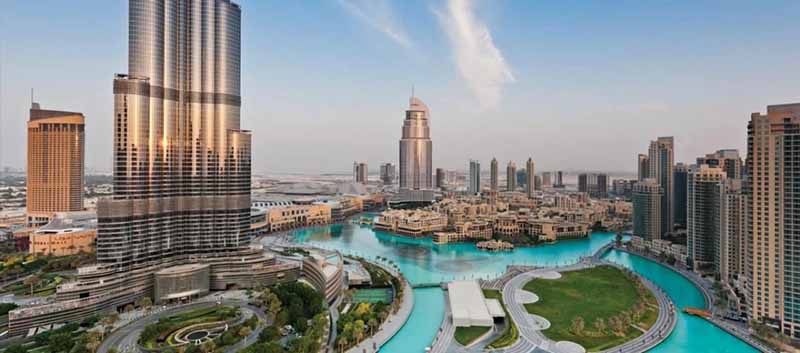 Scenic view of Downtown Dubai with Burj Khalifa and Dubai Fountain area during the autumn season, featuring soft skies and modern architecture