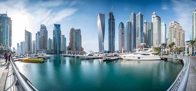 Luxury yachts docked at Dubai Marina with stunning skyscrapers and clear skies during the spring season